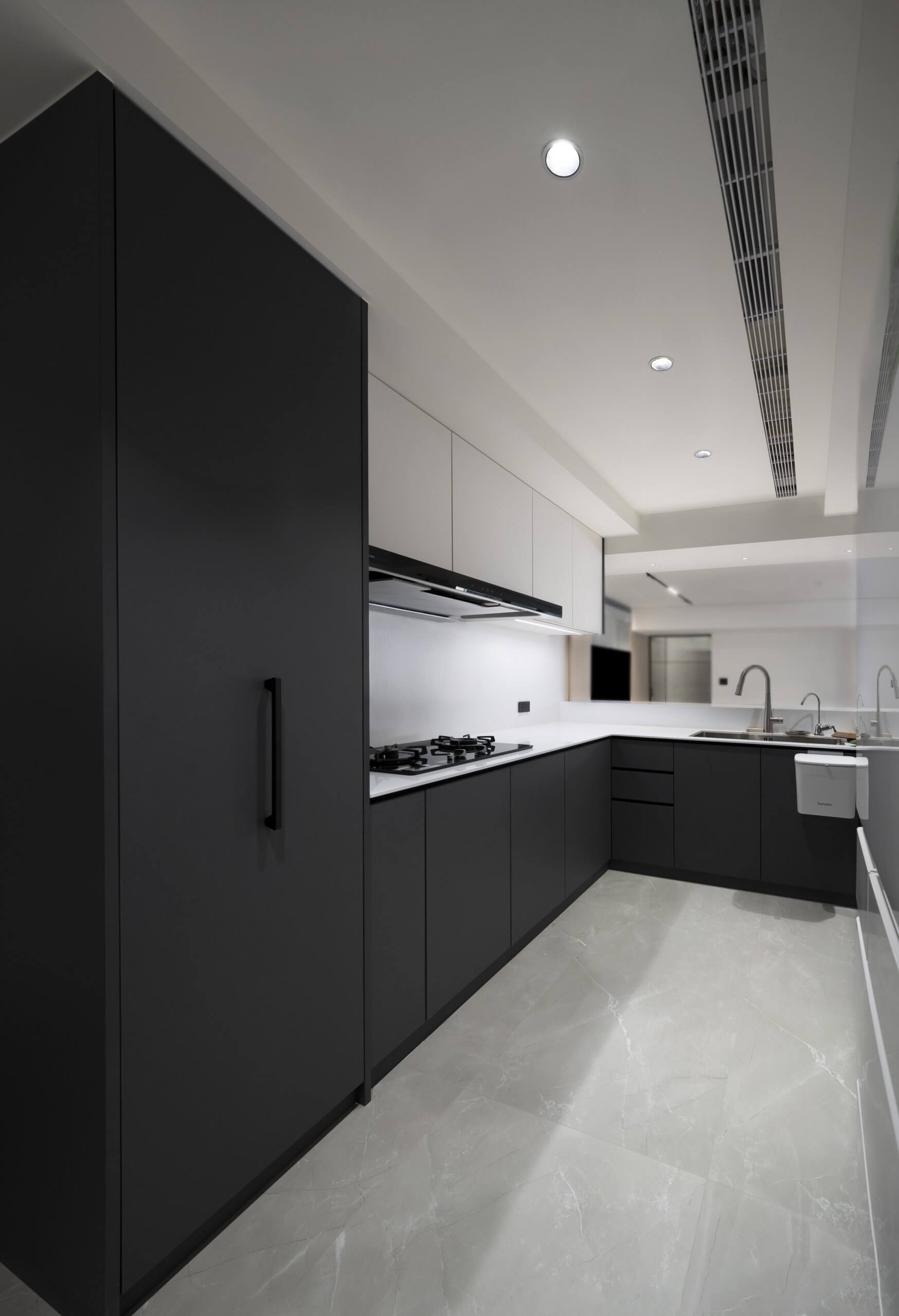 Nhà bếp hiện đại với tủ gỗ màu đen tuyền mờ mượt, mặt bàn màu trắng và phần cứng tối giản.