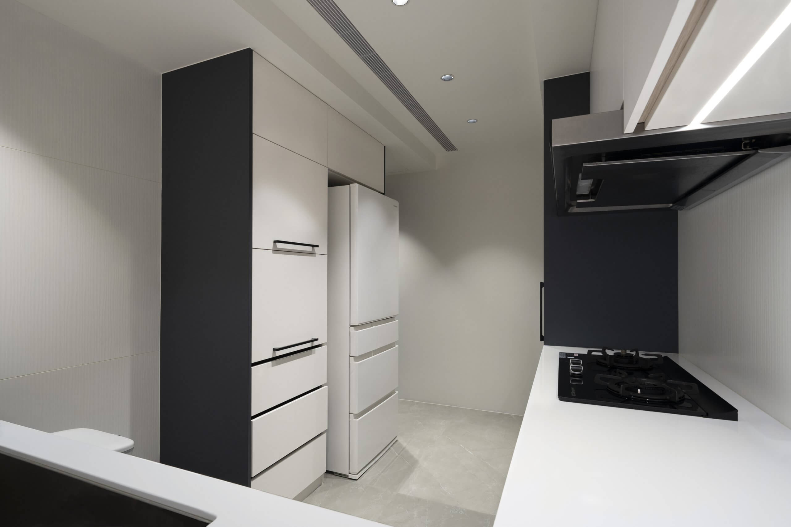 Sleek kitchen with silky matte titanium white laminate cabinets, black handles, and a minimalist design.