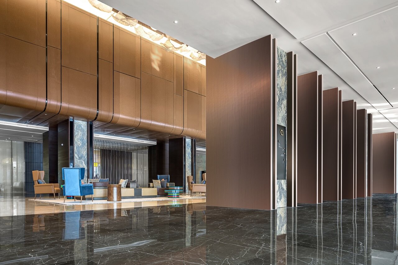 Hotel lobby featuring large wooden walls from Keding with elegant wall panels, creating a warm and inviting atmosphere.
